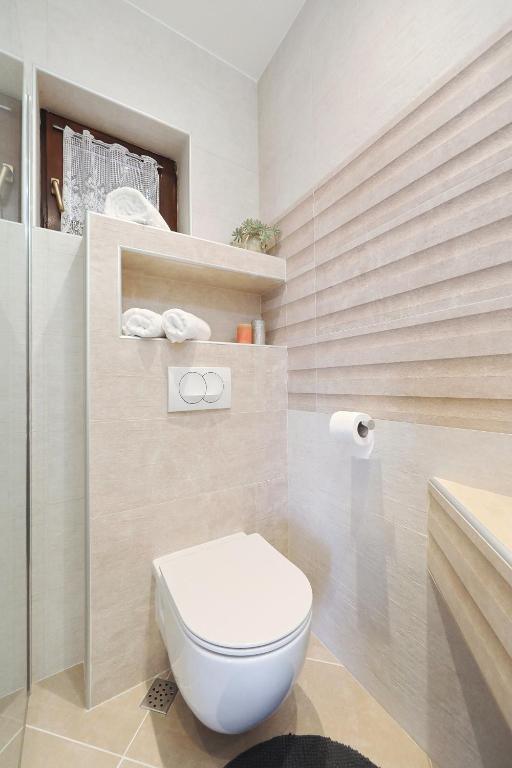 a bathroom with a white toilet and a sink at Villa Dalmatino in Pakoštane