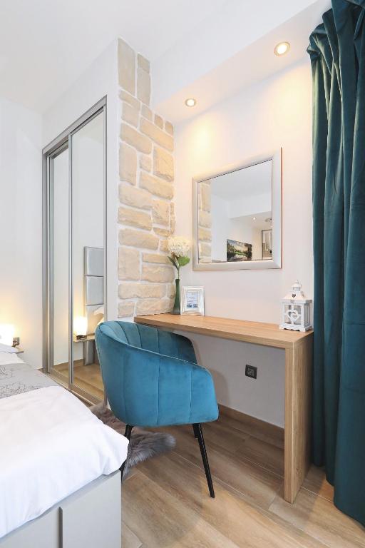 a bedroom with a desk and a blue chair at Villa Dalmatino in Pakoštane