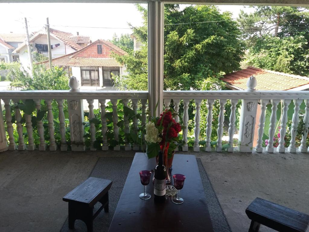 - une table avec des fleurs et des verres à vin sur le balcon dans l'établissement Traianov most, à Kladovo