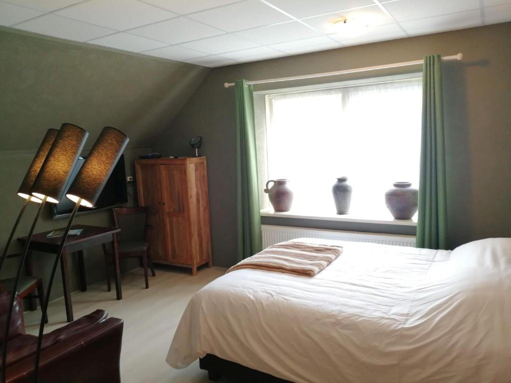 um quarto com uma cama e uma janela com cortinas verdes em De Kapschuur em Stadskanaal