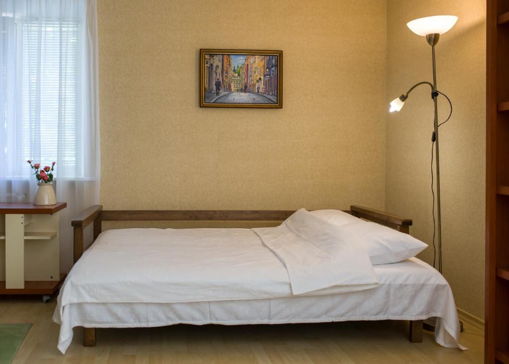 a bedroom with a bed with a picture on the wall at Apartments near Gogol theater in Poltava