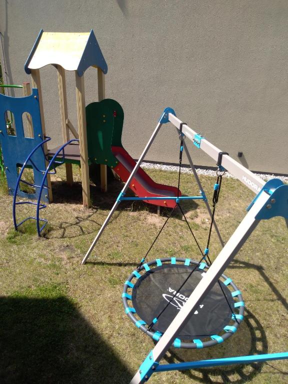a playground with chairs and a swing set at Nikolas Apartamentai - Birstono 7 in Druskininkai