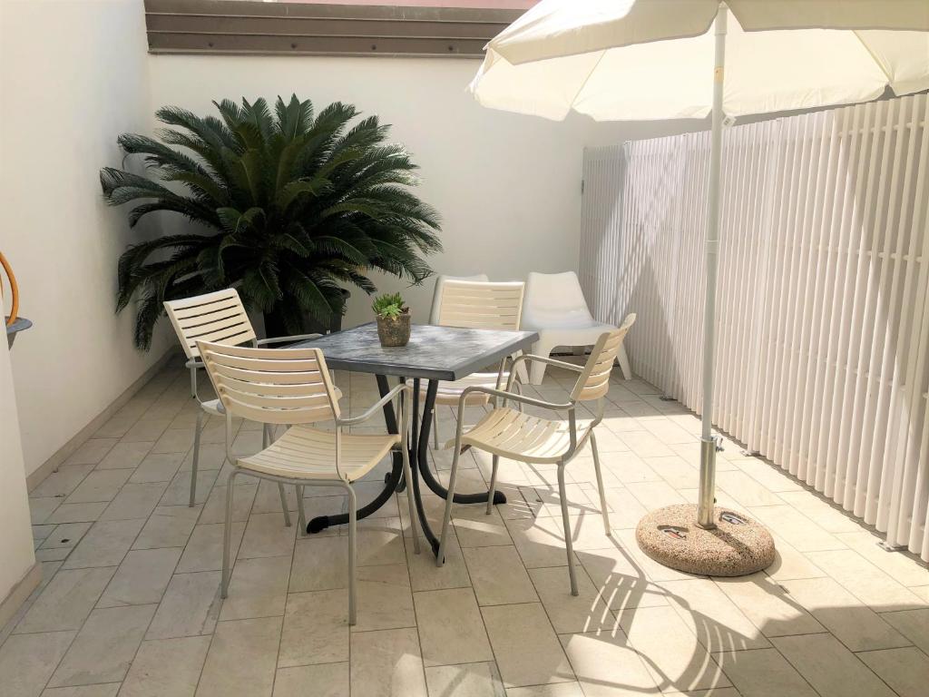 Casa Grazia في غرادو: طاولة وكراسي على شرفة مع مظلة