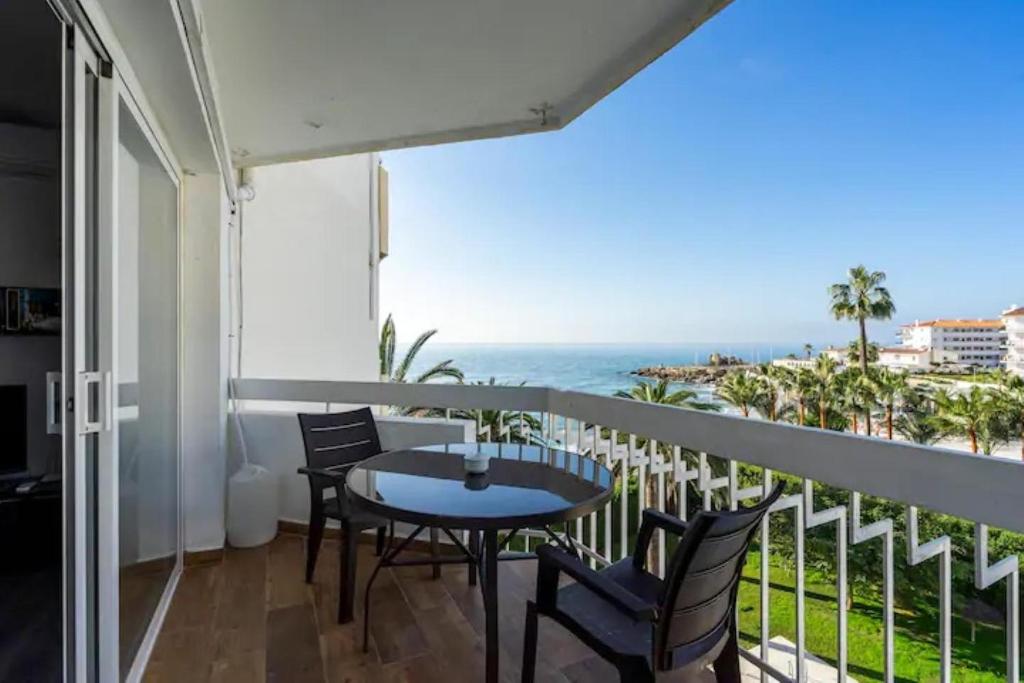 a balcony with a table and chairs and the ocean at Torresol in Nerja