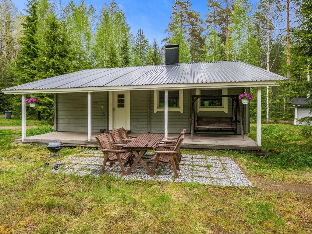 ein kleines grünes Haus mit einem Picknicktisch und Stühlen in der Unterkunft Holiday Home Kuusela by Interhome in Somerniemi