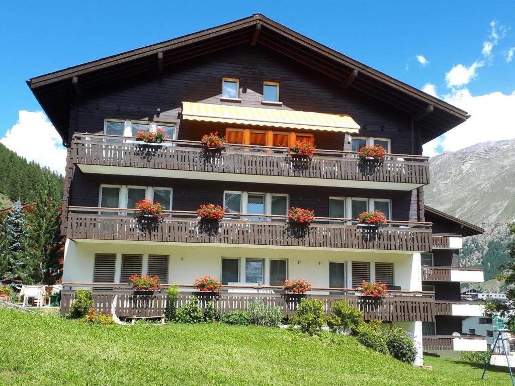 a house with flowerpots on the balconies of it at Apartment La Montanara by Interhome in Saas-Fee
