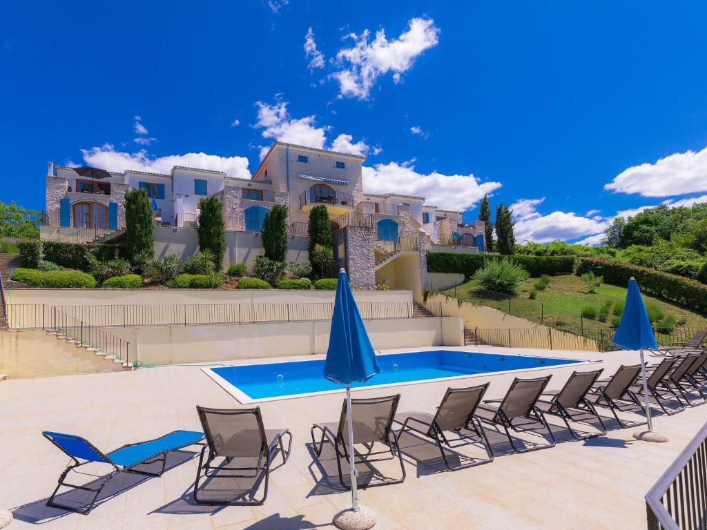 a pool with chairs and a house in the background at Holiday Home Casa Diana by Interhome in Bibali
