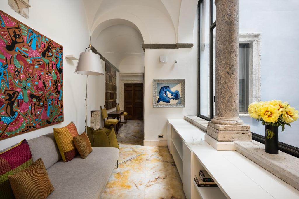 a living room with a couch and a vase of flowers at Palazzo Delle Pietre - Luxury Apartments in Rome