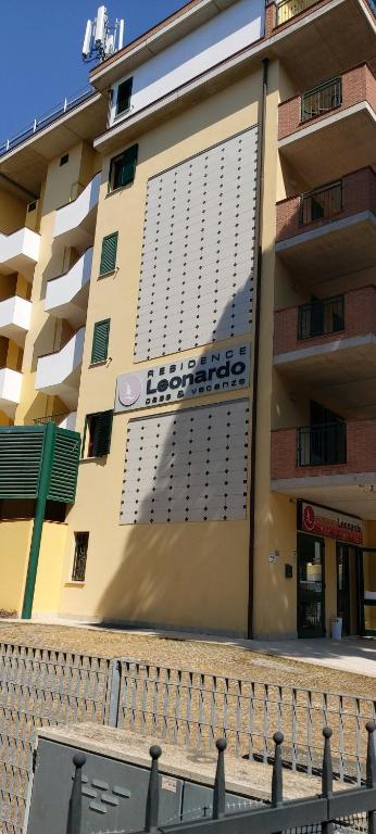 a building with a sign on the side of it at Residence Leonardo in Lido di Spina