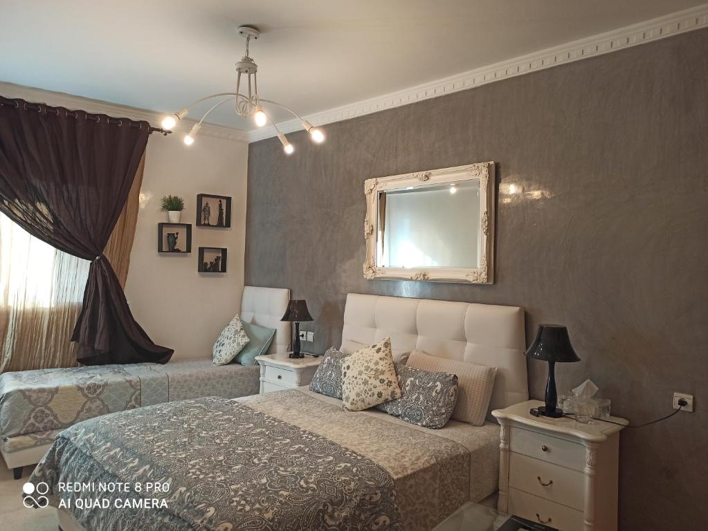 1 dormitorio con cama y espejo en la pared en Chambre haut standing en Rabat