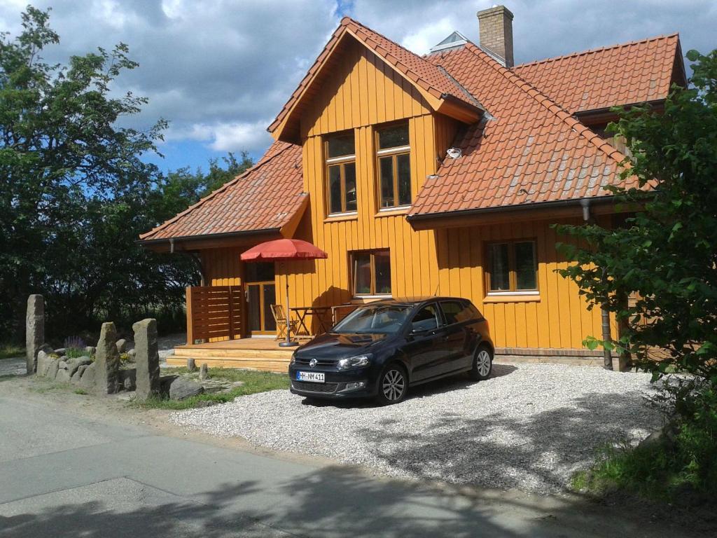a car parked in front of a yellow house at WUIL01001-FeWo-Studio in Wulfen auf Fehmarn