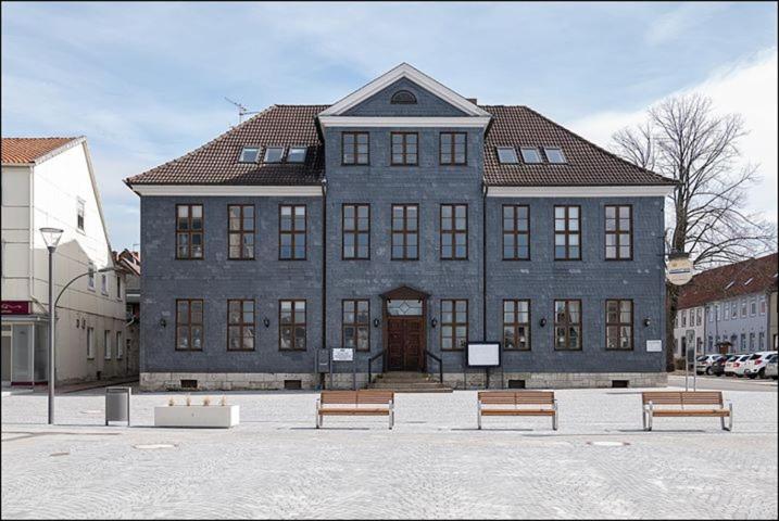 un grand bâtiment avec bancs devant lui dans l'établissement MARKT EINS Gästezimmer, à Schöppenstedt