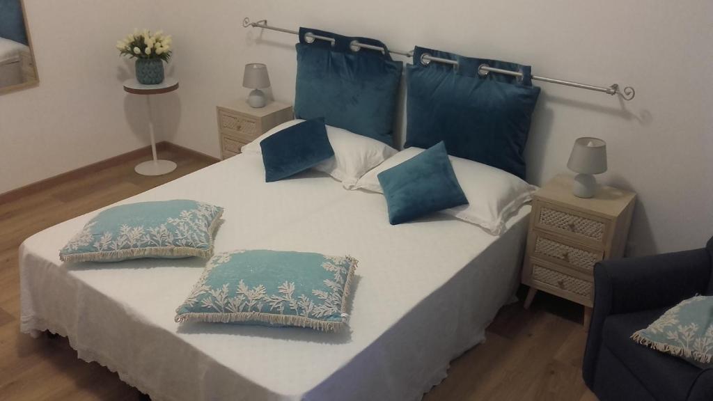 une chambre avec un grand lit avec des oreillers bleus et blancs dans l'établissement Ostia Lido Central Rooms, à Lido di Ostia