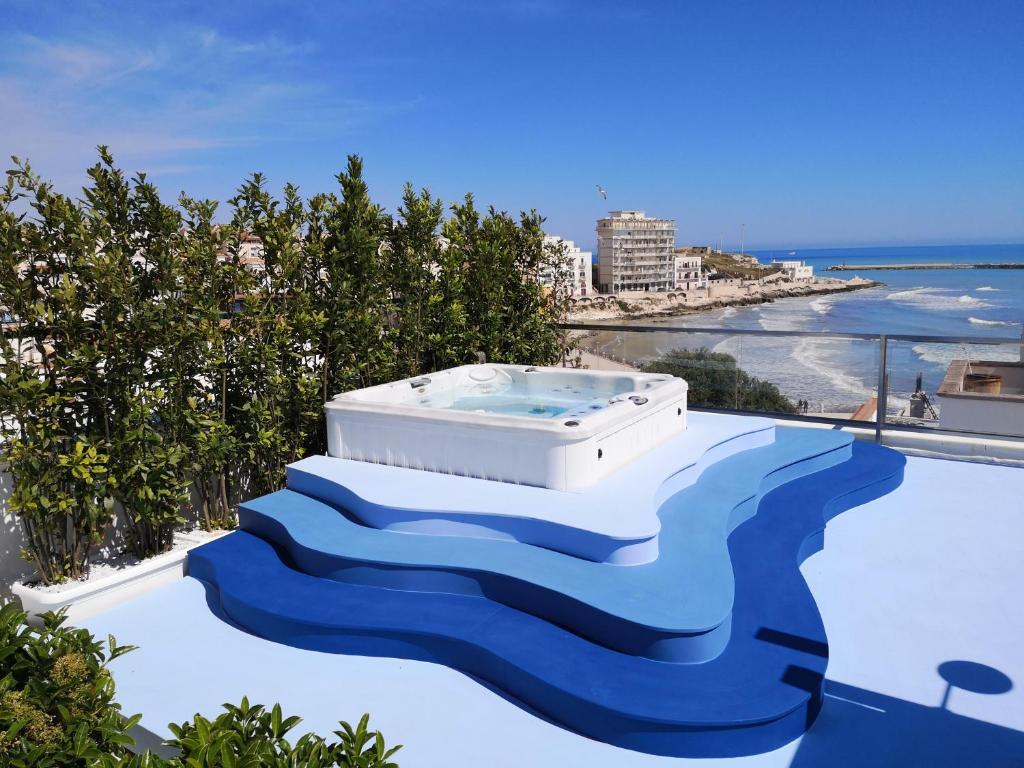 uma banheira de hidromassagem no telhado de um resort com praia em Relais La Pretura em Vieste