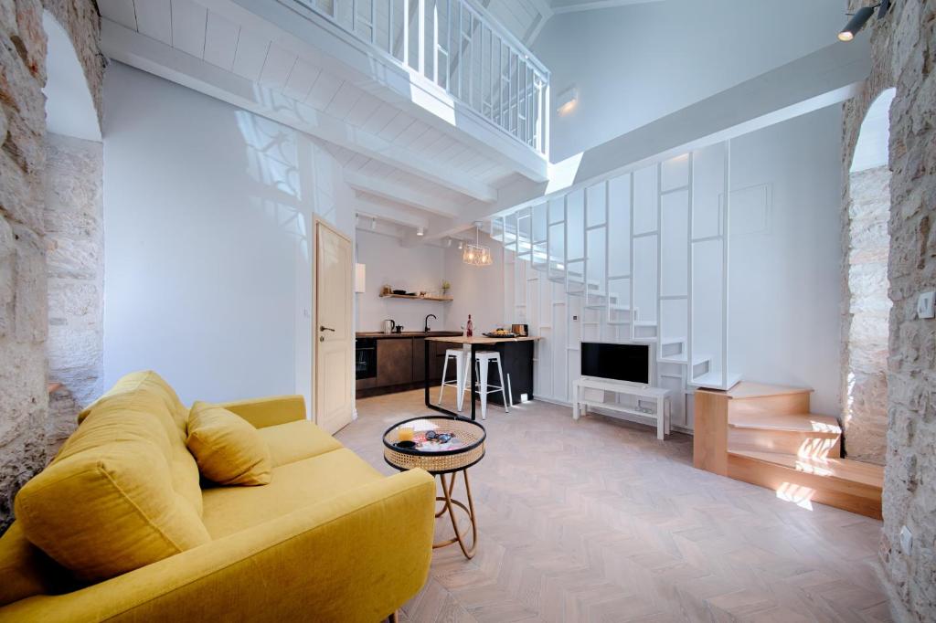 uma sala de estar com um sofá amarelo e uma mesa em Studio Apartment Vicencina em Vis