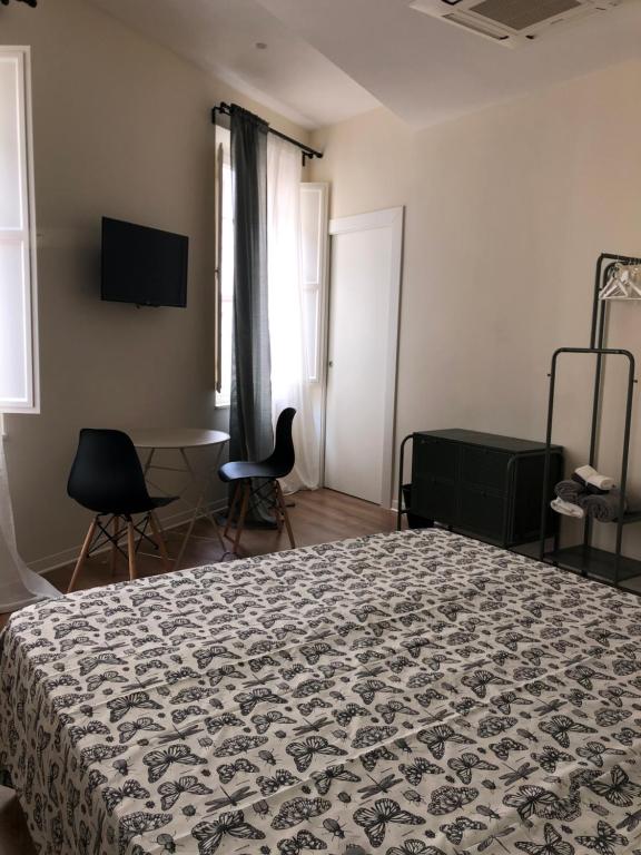 a bedroom with a bed and a table and chairs at L'Iris B&B in Terrazza in Lucca