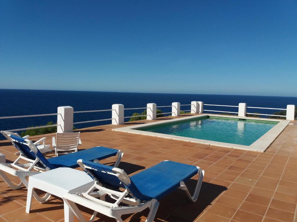 a patio with chairs and a swimming pool on a balcony at OJOS DE MAR views of Es Vedrá in Cala Vadella