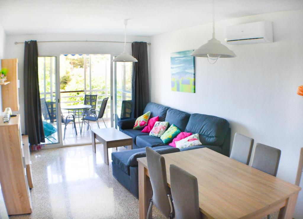 uma sala de estar com um sofá azul e uma mesa em Playa Paraíso em Villajoyosa