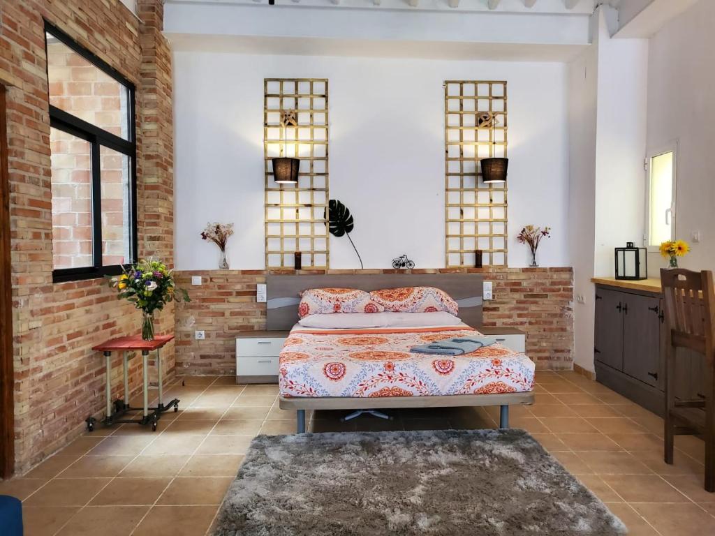 - une chambre avec un lit et un mur en briques dans l'établissement Loft. Old city (Happy Alicante), à Alicante