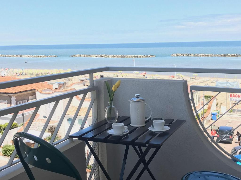 una mesa en un balcón con vistas a la playa en Casa Stefania Igea Marina en Bellaria-Igea Marina