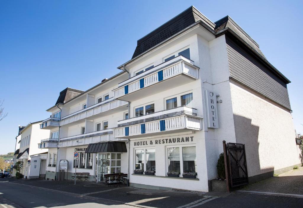 a white building on the corner of a street at Hotel zur Post in Brilon