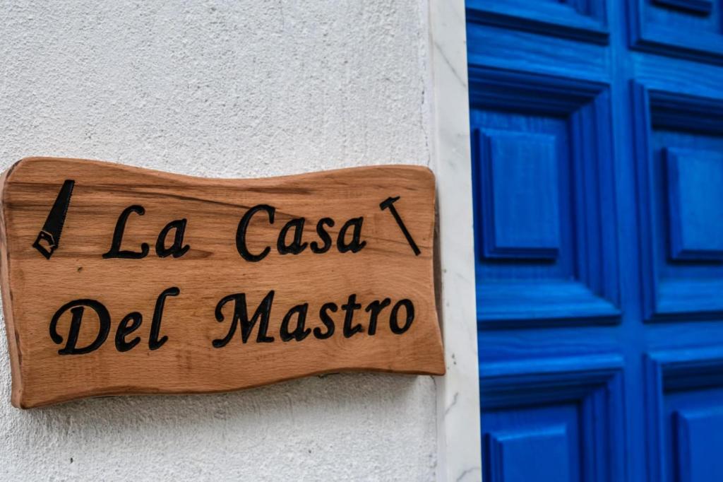 ein Holzschild an der Seite eines Gebäudes in der Unterkunft La Casa del Mastro in Ardore Marina