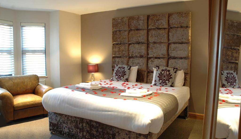 - une chambre avec un grand lit et une chaise dans l'établissement Homestay Hotel Heathrow, à Hounslow