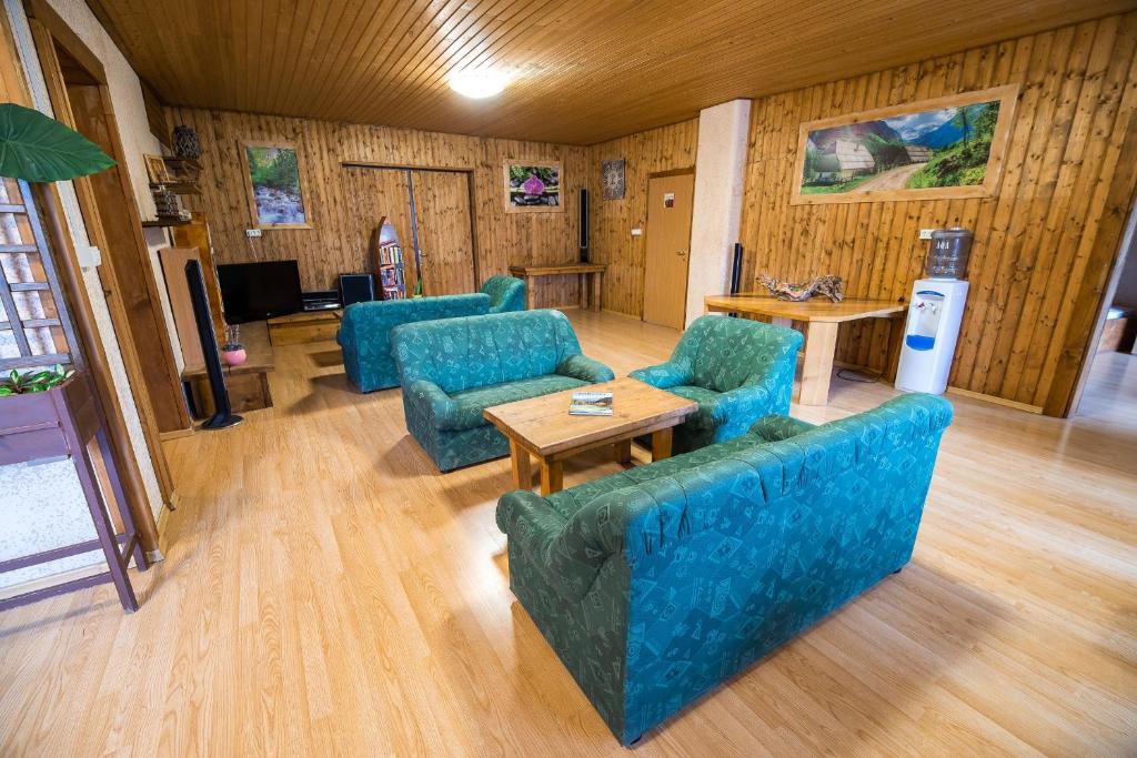 a living room with blue couches and a table at Hostel Paradiso in Tolmin