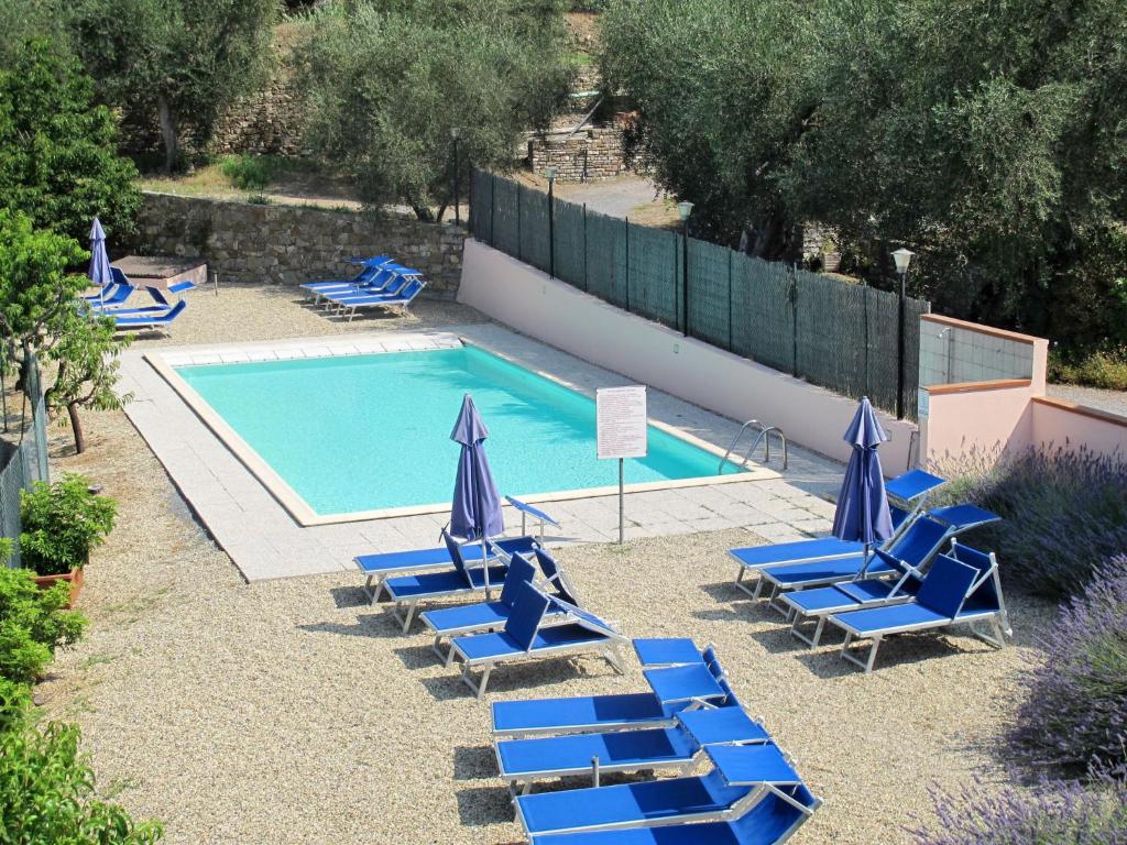 una piscina con tumbonas azules y una piscina en Apartment La Colombera - DIA146 by Interhome, en Diano Castello