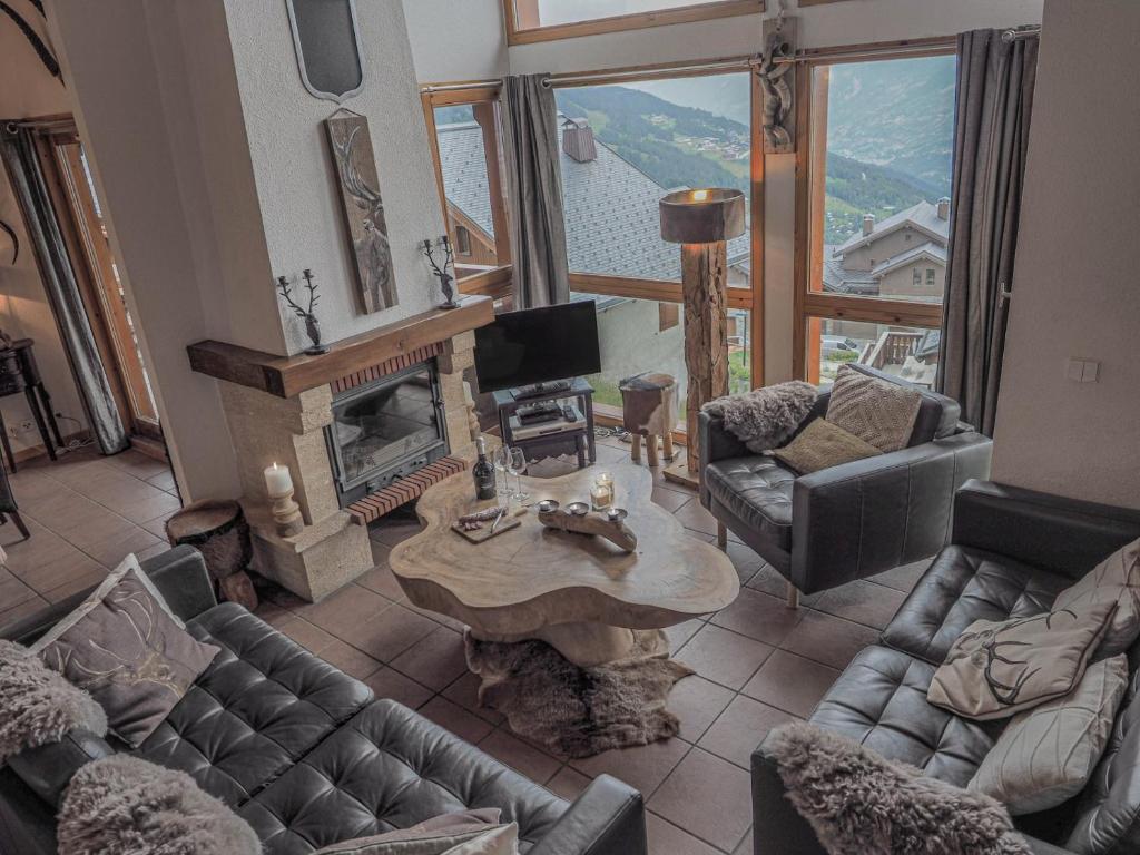 a living room with couches and a table and a fireplace at Chateau Doggestein in Peisey-Nancroix