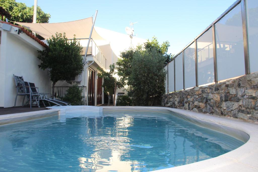 a swimming pool in front of a house at Casa do Rio Fervença in Bragança