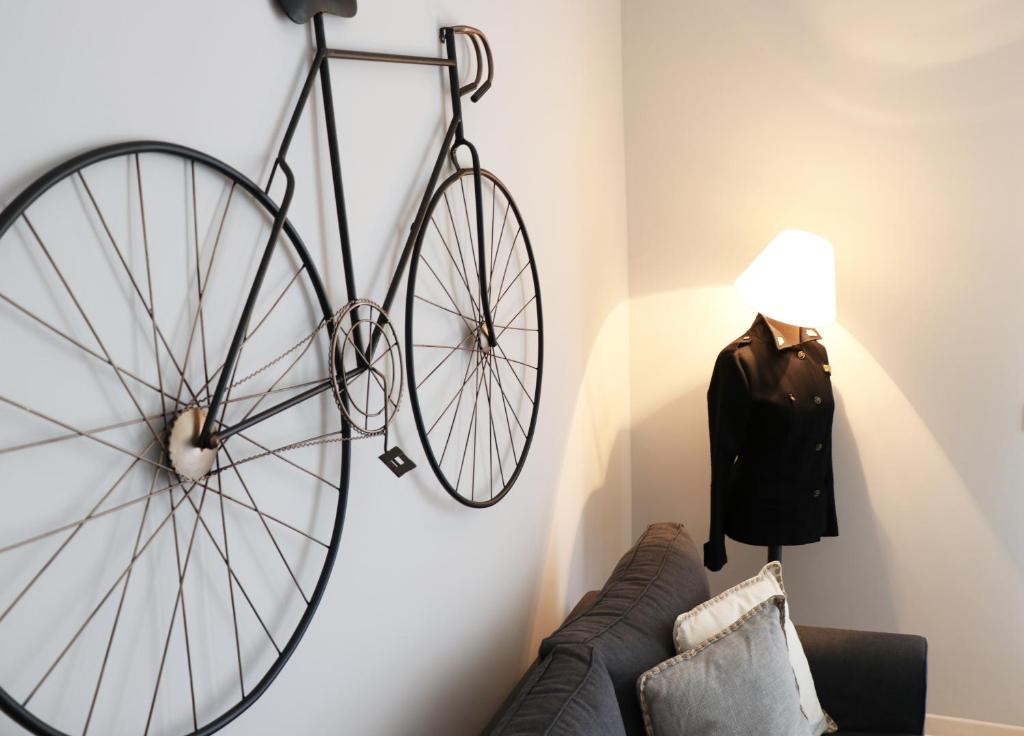 Una bicicleta colgada en una pared junto a un sofá en HABITAT Nafplio bnb - Design Apartment, en Nauplia