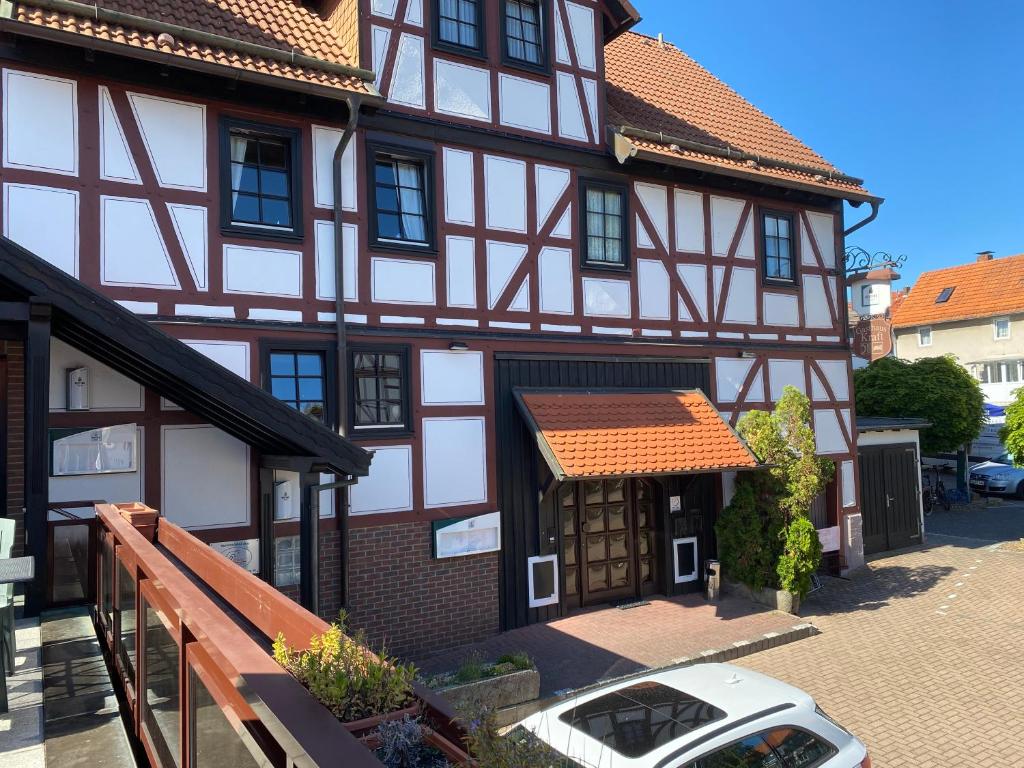 una casa con un coche blanco aparcado delante de ella en Hotel-Gasthaus-Kraft, en Schauenburg