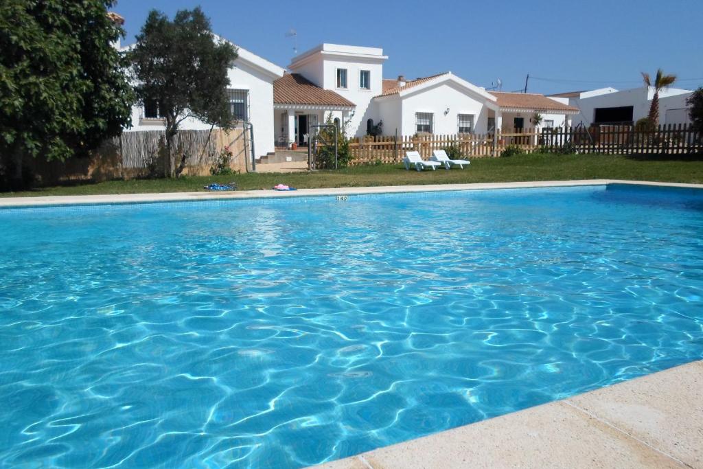 une grande piscine bleue en face d'une maison dans l'établissement Hotel Casa Fina - Adults Recommended, à Conil de la Frontera