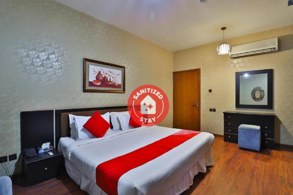 a hotel room with a large bed with a red sign on it at Dome Al Sulaimaniah in Riyadh