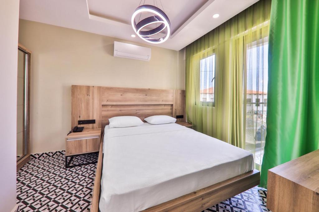 a bedroom with a bed and a green curtain at Zeytin HOTEL in Kaş