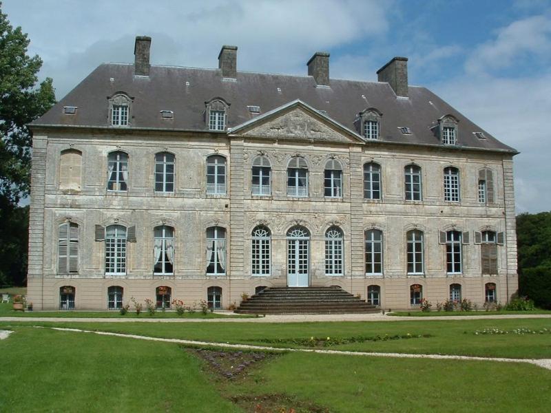 a large stone building with stairs and a grass yard at Château de Couin in Couin