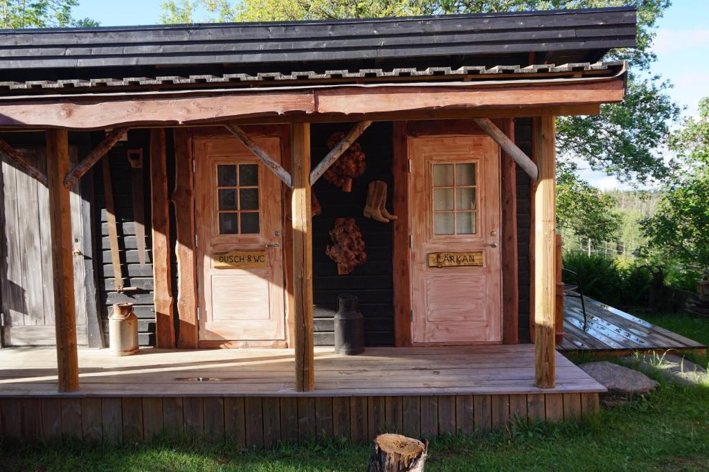 a log cabin with a porch and a door at Kulppis Bed&Breakfast in Härryda