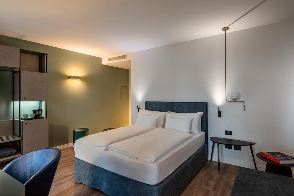 A bed or beds in a room at HT Hotel Trieste