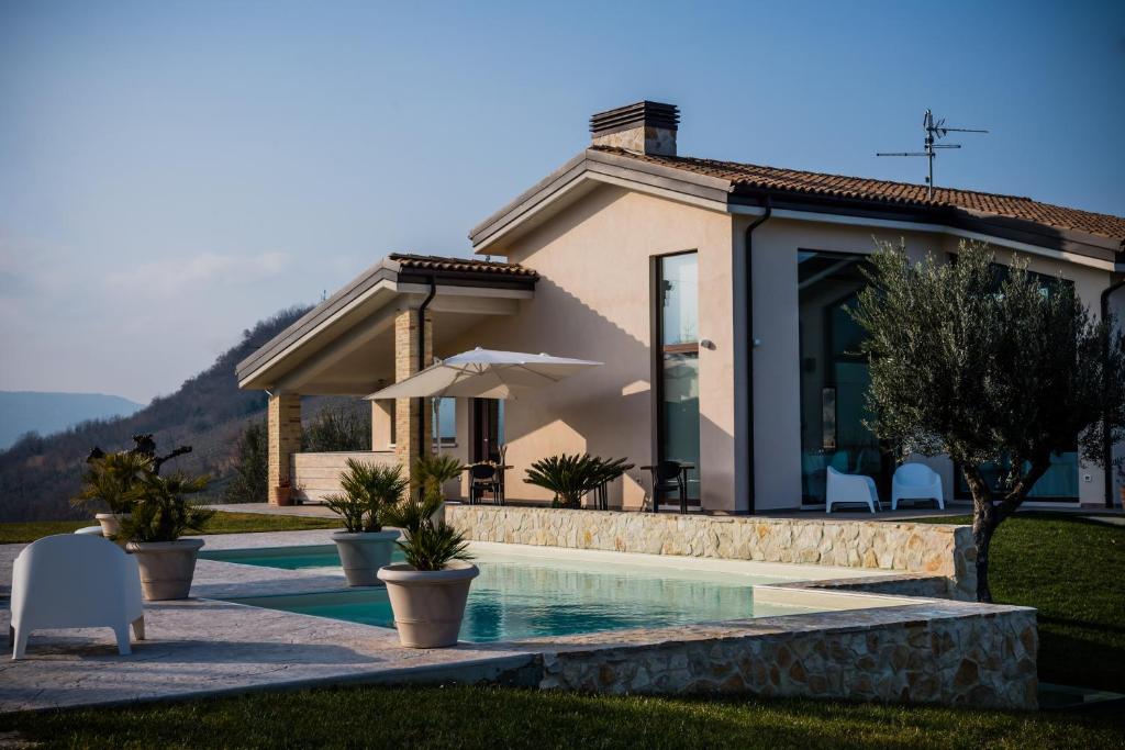 uma villa com uma piscina e uma casa em Ranieri Events and B&B em Casacanditella