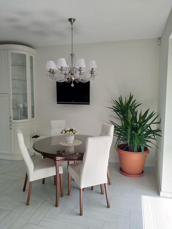 ein Esszimmer mit einem schwarzen Tisch und weißen Stühlen in der Unterkunft Baltieji apartamentai in Palanga