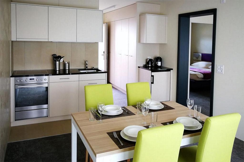 cocina con mesa de comedor y sillas amarillas en wohnMOTEL - Hinterforst en Altstätten