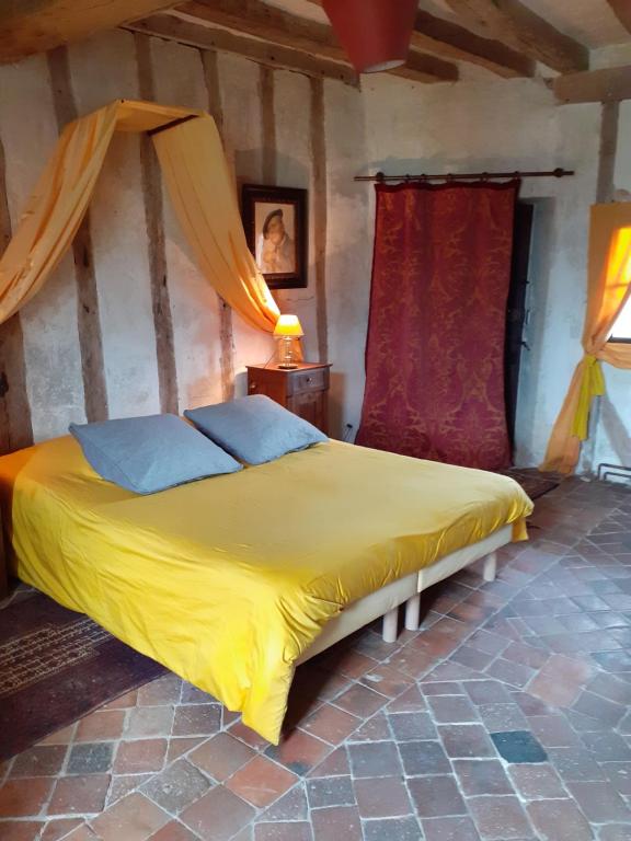 a bedroom with a yellow bed in a room at Chateau de Chémery in Chémery