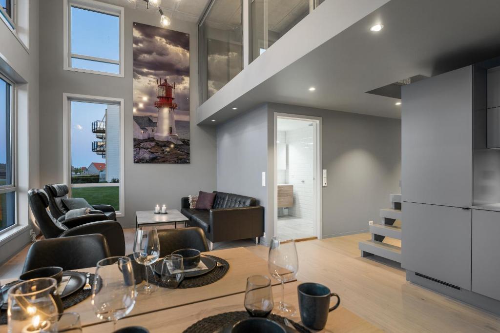 a dining room and living room with a table and chairs at Lindesnes Havhotel in Spangereid