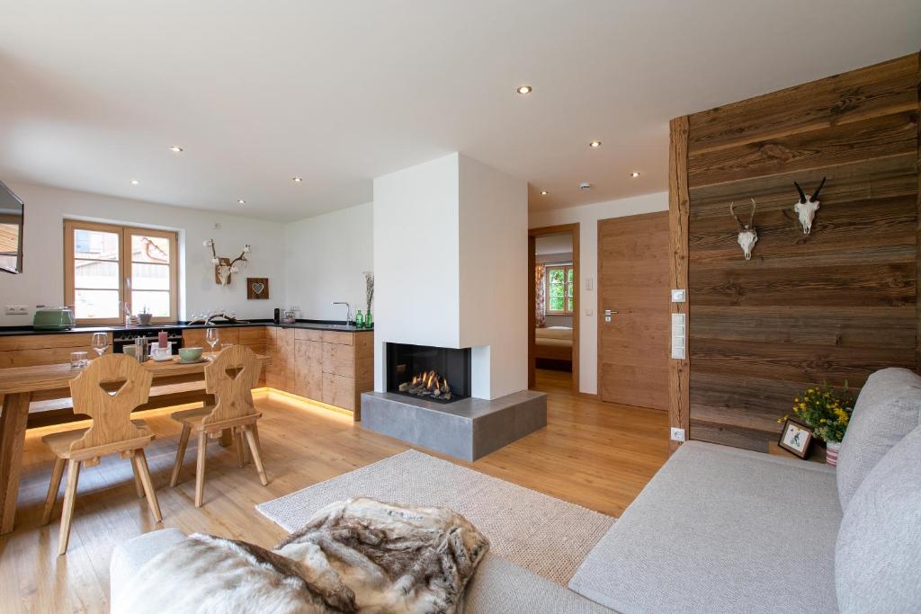 a living room with a fireplace and a table and chairs at Alpinum Junior in Lenggries