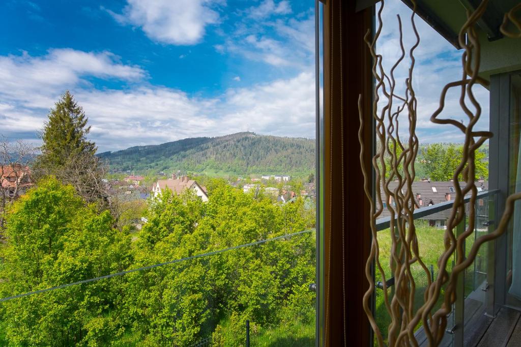 ein Fenster mit Blick auf Bäume und Berge in der Unterkunft Prestige Apartamenty Smrekowa in Zakopane