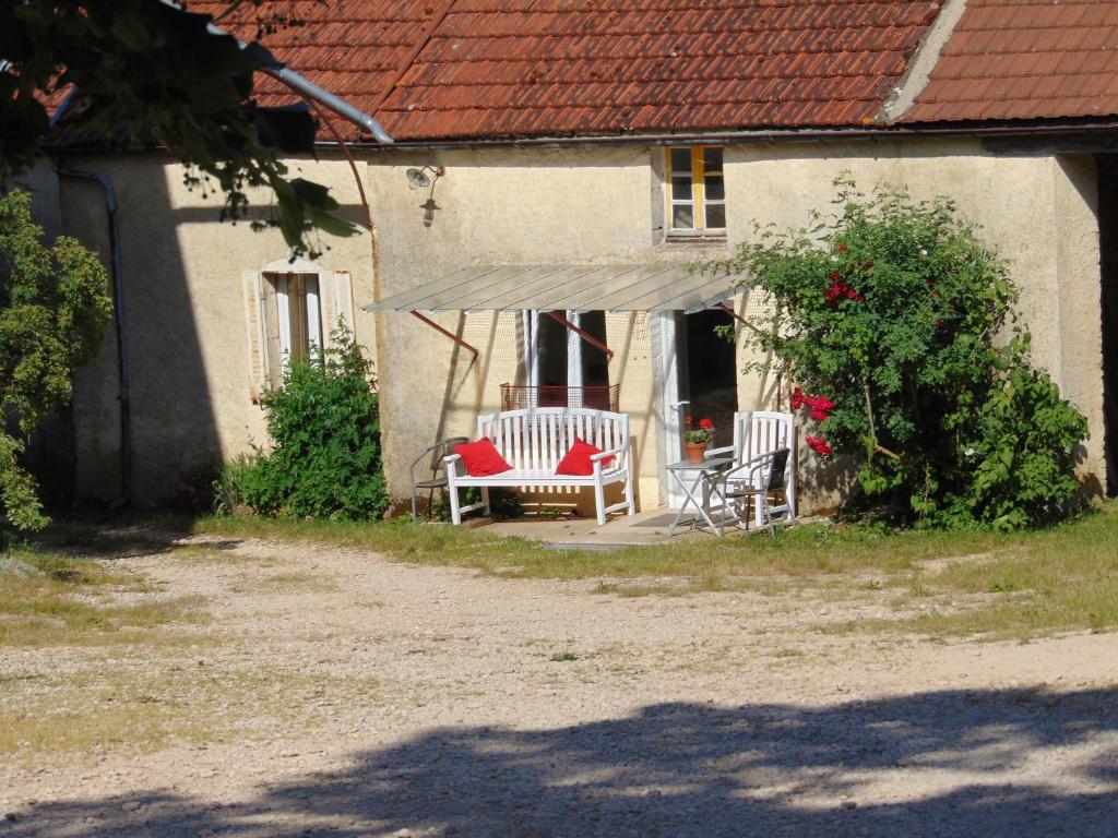une maison avec une terrasse couverte dotée de 2 chaises et d'un auvent dans l'établissement La petite maison, à Grancey-le-Château