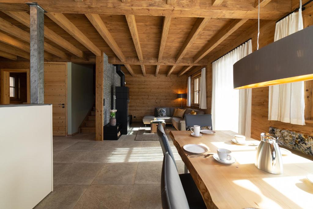 a dining room with a wooden table and chairs at Chalet Frümsel in Wildhaus