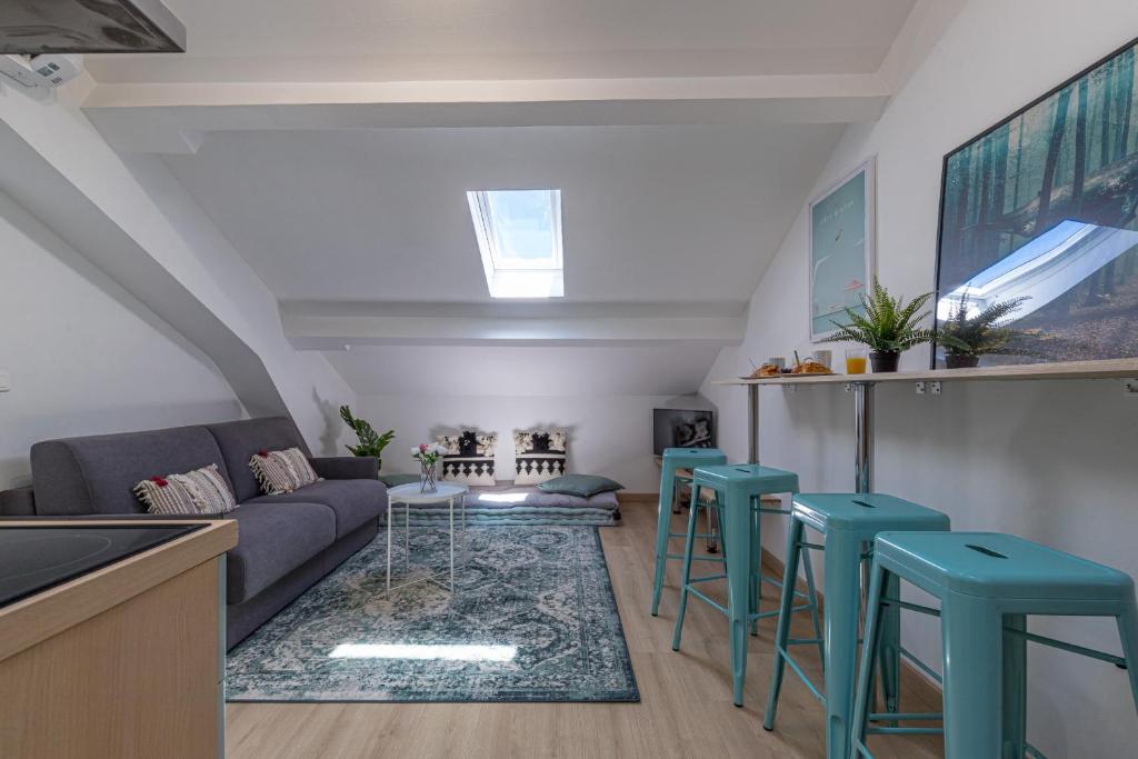 - un salon avec un canapé et des tabourets bleus dans l'établissement 7 DELOYE - Charmant 2 pieces rénové - Dernier étage - Clim, à Nice