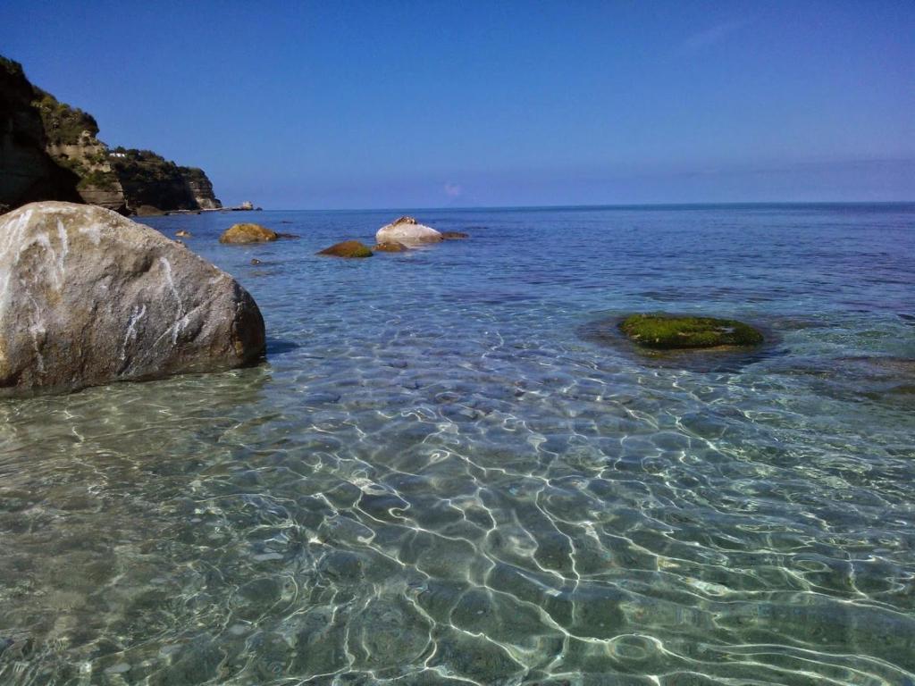Une grande masse d'eau avec des rochers. dans l'établissement Giardino Del Sole, à Tropea